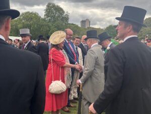 Chair of the Board, Sarah Finnegan-Dehn, shakes hands with The King