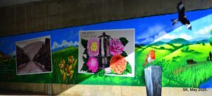 A section of the colourful mural in Cross Keys, depicting rolling hills, a robin on a wooden post and a red kite flying overhead.