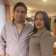 Efren and Lilian pose for the camera. They have dark hair and are dressed smartly in a shirt and smart coat.