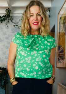 Debra poses for the camera in a green floral shirt